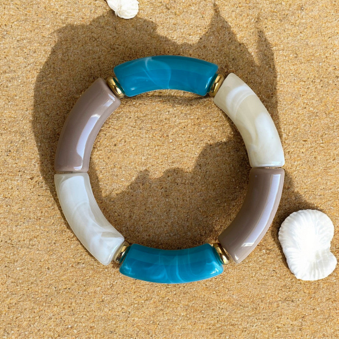Bracelet circulaire en perles incurvées camel, crème marbré et bleu canard marbré avec accents dorés.