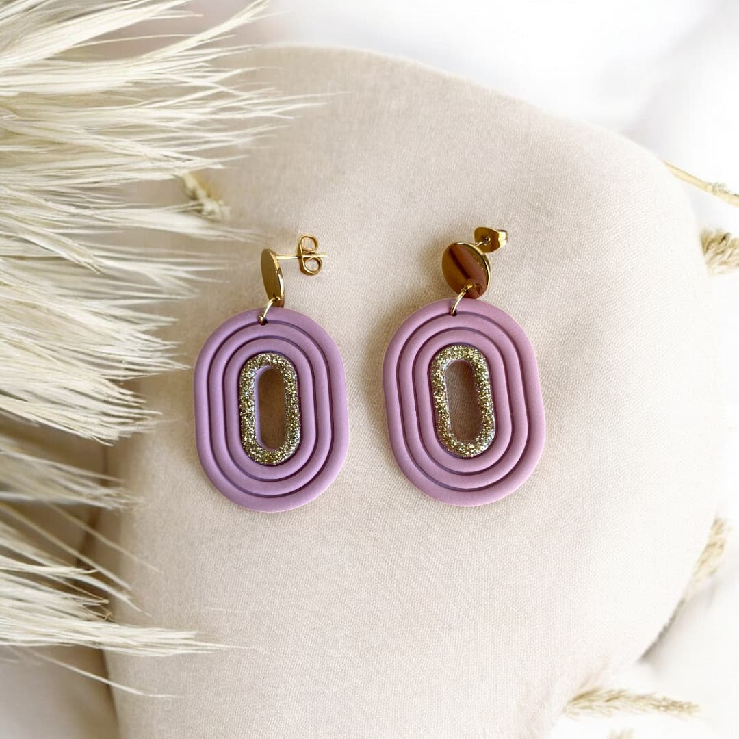 Boucles d’oreilles artisanales Eudora en pâte polymère, avec un liséré doré scintillant et une attache en acier inoxydable doré.