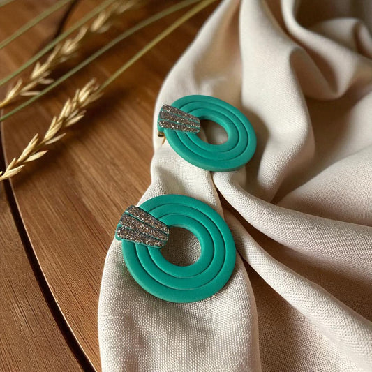 Boucles d’oreilles artisanales en pâte polymère vert Jade, ornées de paillettes Champagne.