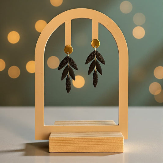 Boucles d’oreilles noires pailletées Calypso en pâte polymère, design articulé et dorures.