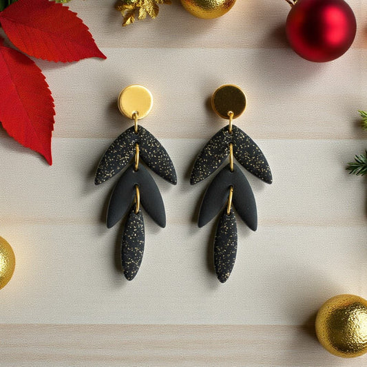 Boucles d’oreilles noires pailletées Calypso en pâte polymère, design articulé et dorures.
