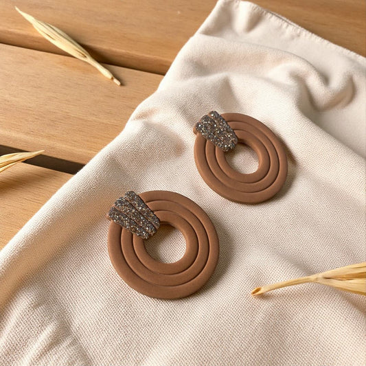 Boucles d’oreilles artisanales en pâte polymère marron cuir, ornées de paillettes Champagne.