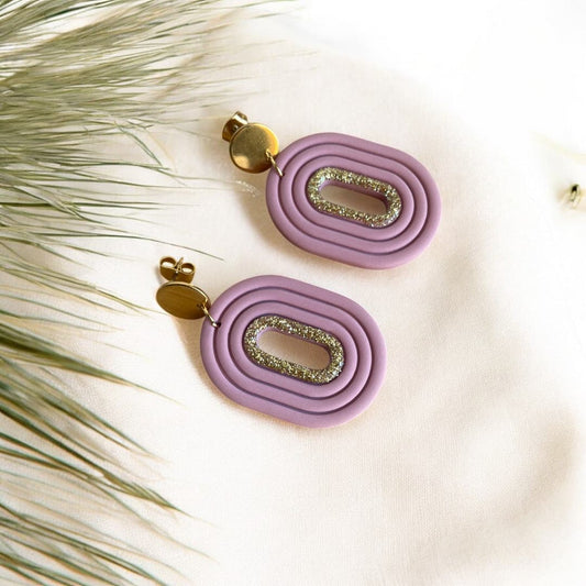 Boucles d’oreilles artisanales Eudora en pâte polymère, avec un liséré doré scintillant et une attache en acier inoxydable doré.