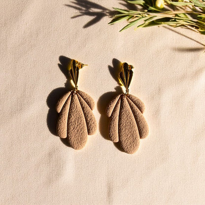 Boucles d’oreilles Flora avec pétales en pâte polymère rose texturée et clous dorés en forme de feuille.