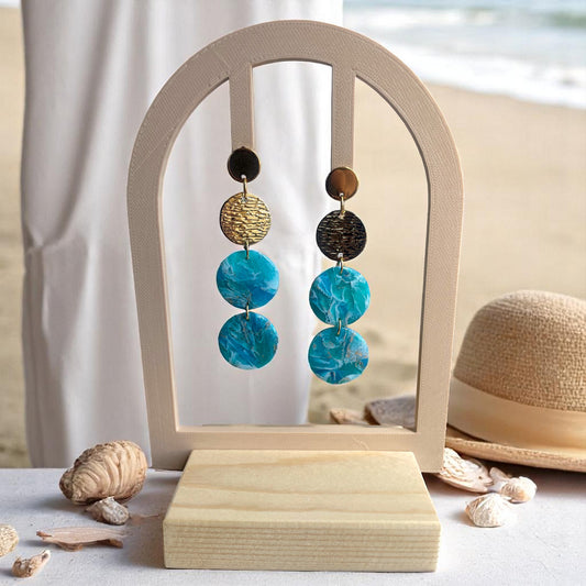  les boucles d’oreilles Azura, inspirées des profondeurs de l’azurite et des reflets dorés du soleil. 