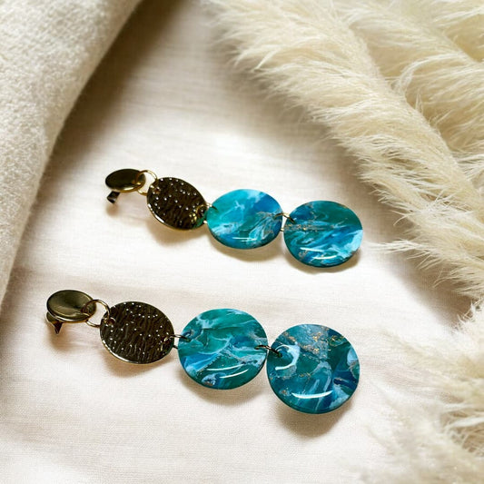 les boucles d’oreilles Azura, inspirées des profondeurs de l’azurite et des reflets dorés du soleil. 